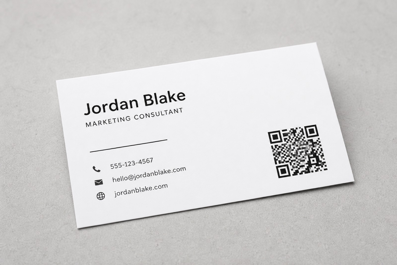 Modern business card with a QR code in the corner on a clean desk